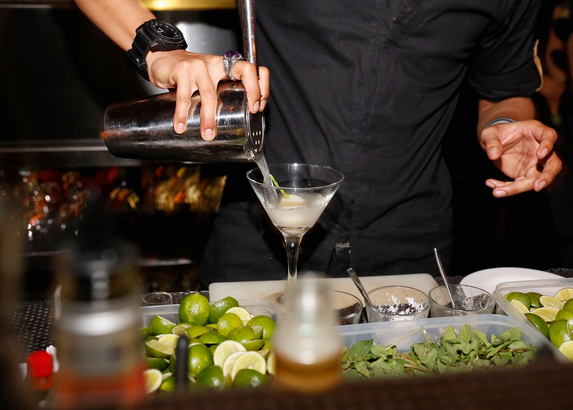 Unrecognizable bartender making cocktail behind bar